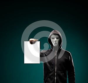 Computer hacker in white mask and hoodie. Obscured dark face. Data thief, internet fraud, darknet and cyber security