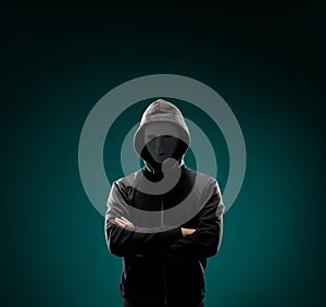 Computer hacker in white mask and hoodie. Obscured dark face. Data thief, internet fraud, darknet and cyber security