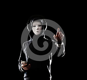 Computer hacker in white mask and hoodie. Obscured dark face. Data thief, internet fraud, darknet and cyber security