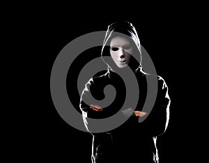 Computer hacker in white mask and hoodie. Obscured dark face. Data thief, internet fraud, darknet and cyber security