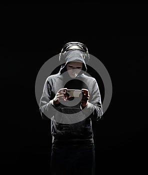 Computer hacker in white mask and hoodie. Obscured dark face. Data thief, internet fraud, darknet and cyber security