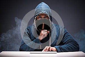 The computer hacker working in dark room