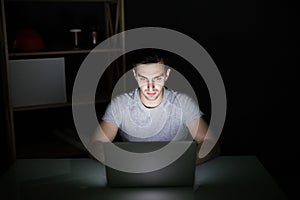 Computer hacker working in dark room programing at night