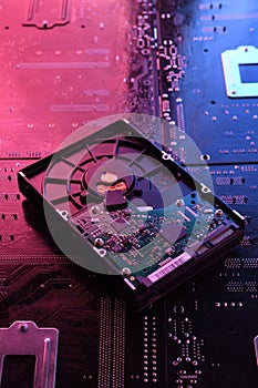 Computer Hard disk drives HDD , SSD on circuit board ,motherboard background. Close-up. With red-blue lighting