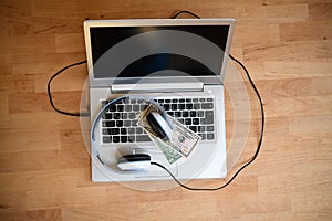 Computer with headphones and dollar bank notes