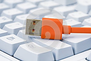 Computer keyboard with big buttons and orange USB cable