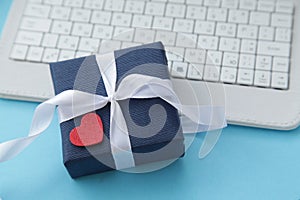 Computer keyboard, gift box dark blue color, heart on blue background. Gift for men. Father's day. Shopping online