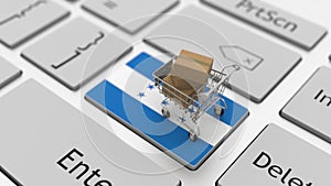 Computer keyboard key with flag of Honduras and shopping cart with cartons, online shopping conceptual 3d rendering