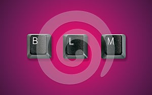 Computer keyboard keys spelling BLM, isolated on a dark purple red background