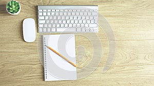 Computer keyboard, mouse and notebook with a pencil on the table