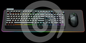 Computer keyboard and mouse on professional pad isolated on black background.