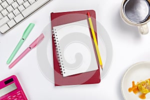 Computer keyboard and note book with pen and pencil