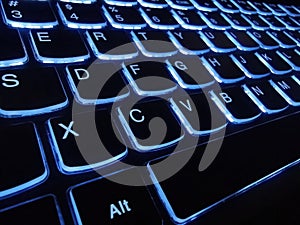 Computer keypad glowing in dark. Illuminated keyboard. Closeup view of computer keyboard buttons. Computer keyboard with glowing