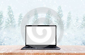 Computer,laptop with blank screen on snowfall in winter season