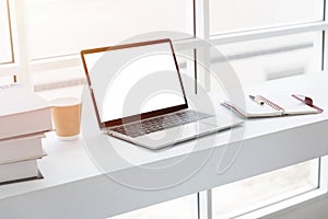 Computer laptop blank screen on white clean working table cozy desktop work space in cafe