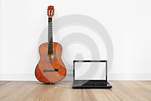 Computer laptop, blank white screen with acoustic guitar