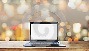 Computer laptop blank white screen on wooden desk, with blurry Bokeh light background