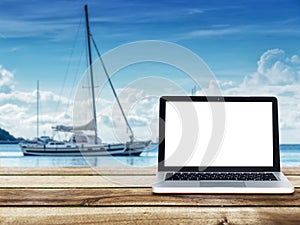 Computer laptop with blank white screen on wooden table