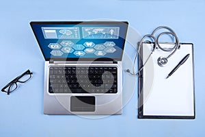 Computer laptop, stethoscope and clipboard