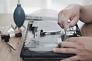 Computer literacy repair men hands use screwdriver remove nut of hard disk of laptop