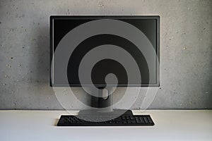 Computer monitor with blank black screen on the desk with copy space.