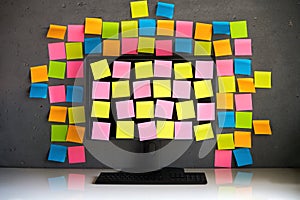 Computer monitor full of blank colorful sticky notes reminders