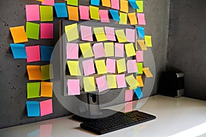 Computer monitor full of colorful sticky notes reminders