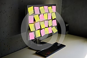 Computer monitor full of colorful sticky notes reminders