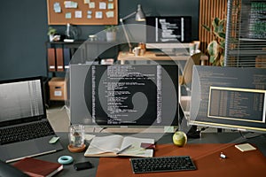 Computer Monitors Displaying Programming Code on Desk in Modern Office