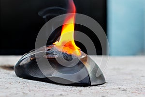 Computer mouse in flames. Careless handling of equipment, fire