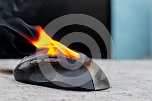 Computer mouse in flames. Careless handling of equipment, fire