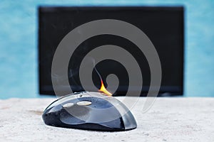 Computer mouse in flames. Careless handling of equipment, fire