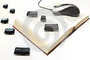 Computer mouse and keys on a book spread