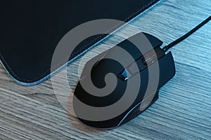 Computer mouse with mousepad on wooden table, flat lay