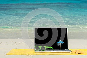 Computer notebook on beach - business travel background