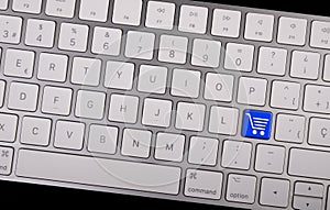 Computer notebook keyboard with icon shopping cart on key. E-commerce concept