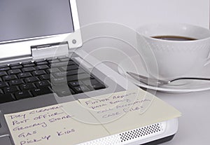 Computer with notes and cup of coffee