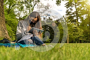 Computer outdoor. Student girl working on laptop, tablet in summer park. Woman person business nature outside with