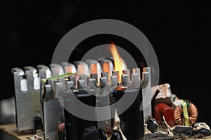 computer power burning, on a black background, close-up, short circuit, electrical equipment ignition