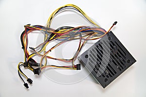 Computer power supply unit with multicolored wires and connectors isolated on a white background, repair of equipment telephony