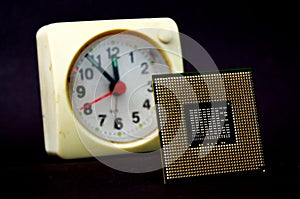 The computer  processor on a dark background and vintage clock