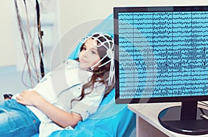 Computer recording brain waves of little girl undergoing electroencephalography