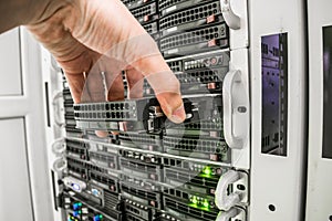 Computer repair in the server room of the data center. The specialist performs the replacement of the hard disk in the data