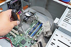Computer repairman unscrews the motherboard from the case