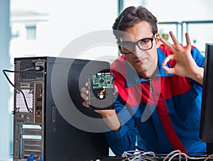Computer repairman working on repairing computer in IT workshop