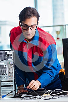 Computer repairman working on repairing computer in IT workshop