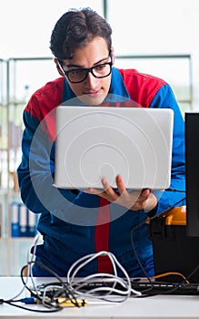Computer repairman working on repairing computer in IT workshop