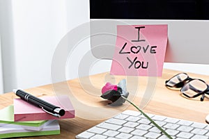 Computer Screen with I Love You Note and a Rose on the Keyboard
