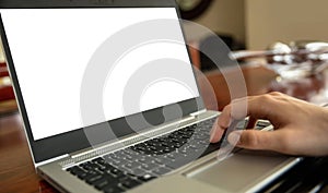 Computer screen mockup. Laptop with white blank screen on a wood desk, office background, copy space