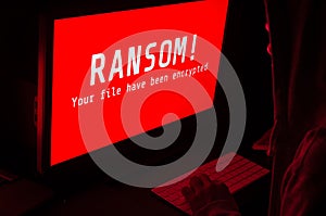 Computer screen with ransomware attacks alert in red and a man k